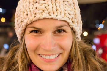 Junge Frau lächelt und trägt eine Wintermütze