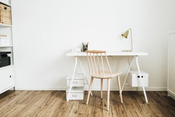 Desktop table and wooden chair in white room. Home office desk workspace.