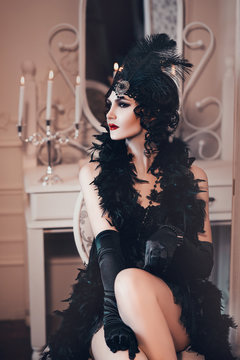 elegant woman in retro style of the 20s, lady flapper in a black dress, dark hair and a bandage, feather boa, long gloves. image of a gangster girl on a party, old fashion. art processing