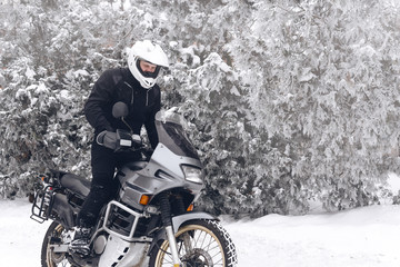 Rider man in action on adventure motorcycle. Winter fun. snowy day. ride on snow road. dual sport...