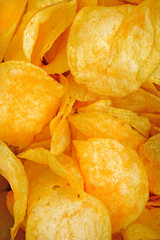 Background of golden chips large slices with seasoning throughout the frame, appetizing food background