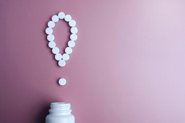 Pharmaceutical.The exclamation mark of the pills.Exclamation point. White pills on a pink...