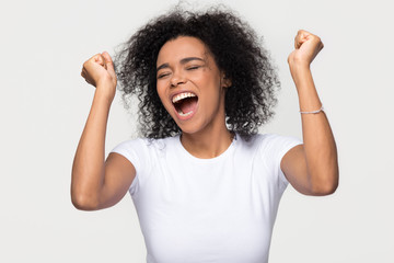Overjoyed young african american woman screaming with joy celebrating victory