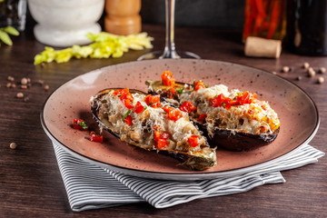 European Spanish cuisine. Baked eggplants with meat and vegetables, parmesan cheese. White wine on the table. Close-up background image. Beautiful serving dishes in the restaurant.