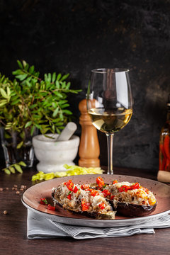 European Spanish cuisine. Baked eggplants with meat and vegetables, parmesan cheese. White wine on the table. Close-up background image. Beautiful serving dishes in the restaurant.