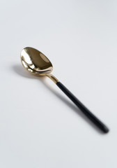 New luxury Golden cutlery view from above on a isolated white background. Top view. Black spoon for a festive table for a wedding, birthday or party.