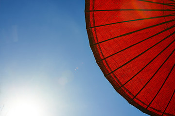 Abstract close up of a red sun umbrella with a blue sky