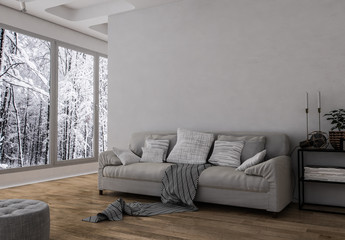 Gemütliches Sofa mit vielen Kissen im großen Raum vor Fensterfront mit Winterlandschaft 
