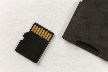 Close-up of micro SD memory card and SD adapter isolated on white copy space background. Modern...
