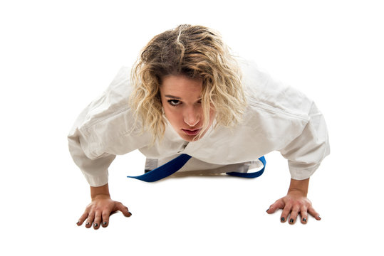 Full body of woman wearing martial arts outfit standing in plank
