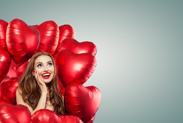 Beautiful woman with red balloons on banner background. Surprised girl, Valentine's day concept . Expressive facial expressions