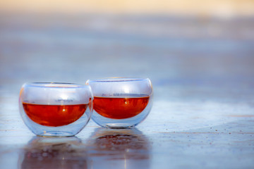 Glass of drink tea coffee wine brandy on the background of nature and ice