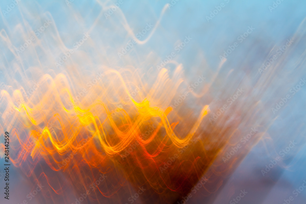 Sticker Abstract blurred light effect of orange waves on a blue background. Long exposure photo of moving camera