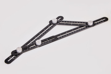 Black multi function Ruler isolated on white background. Ultimate Irregular Shape Copy Tool. Universal Easy Angle Ruler. Multi Angle Measuring Tool.
