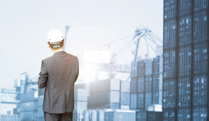 Fototapeta premium The abstract image of the businessman standing and looking up to business of import exportr during sunrise. the concept of shipping, shipyard, logistics and transportations.