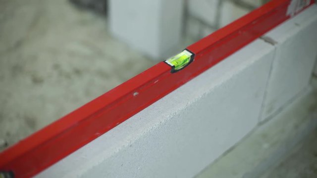 checking evenness of aerated concrete wall with bubble level