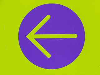 A green arrow in a purple circle on a green background image with copy space