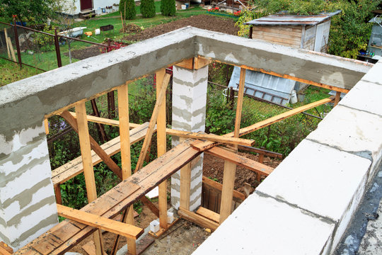 view of pit dug under foundation for a barbecue in annex to house. Site on which the walls are built of gas concrete blocks with wooden formwork