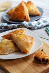 Puff pastry triangles filled minced meat, onion and spices