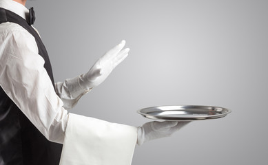 Waiter serving with white gloves and steel tray in an empty space
