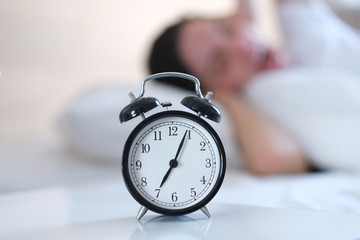 Young woman is not ready to wake up.Alarm o'clock. Time to wake up.
