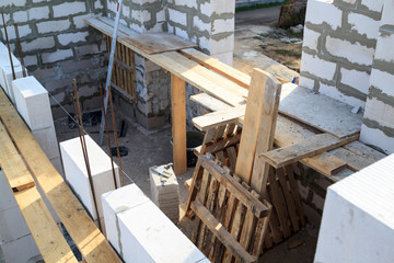 Obraz na płótnie Canvas view of laying walls of first floor, fittings for filling supporting columns. Construction of country house made of foam blocks