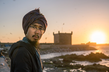 Young Asian Bearded Tourist man with Dreadlocks and scarf on head Having Fun in Essaouira, Morocco...