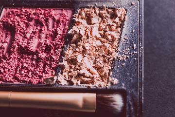 crushed blush and bronzer powders with brush, close-up shot