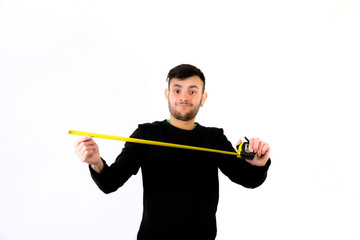 Smiling bearded young man worker nice and modern holding measure tape isolated on a white background