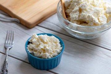 Curd cheese in a bowl on wooden background 