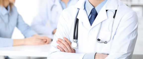 Male doctor standing upright with crossed arms, unknown physician at work. Medicine concept