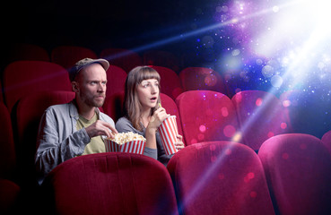 Obraz premium Romantic couple cuddling and watching the miraculous part of the film