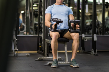 Fototapeta premium Muscular man holding dumbbell at the gym.