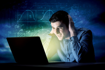 Young handsome businessman working late at night in the office with blue mathematic charts in the background