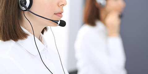 Call center. Group of operators at work. Focus on young brunette woman. Business  concept