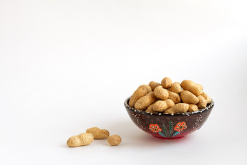 nuts in shell on clay cup on white background, copy space for text