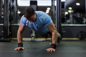 Image of an attractive man doing push-up at the gym.