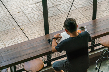 Young man reading books in the coffee shop