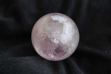 Rose quartz crystal ball on black background