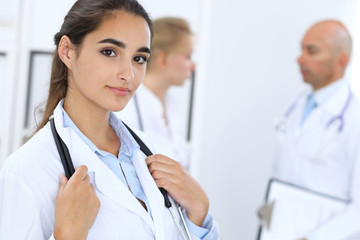 Fototapeta premium Portrait of young doctor woman in hospital. Hispanic or latin american staff in medicine