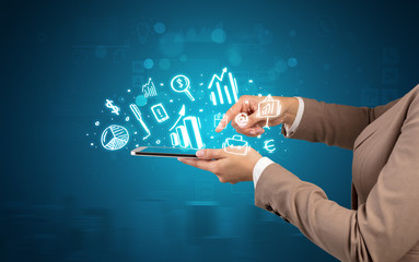 Elegant hand holding tablet with chalk drawn social media symbols above
