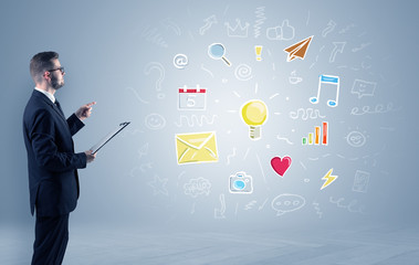 Young manager presenting new plan  illustrated by colourful chalk drawn icons and symbols around
