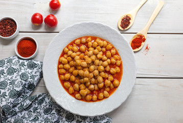 Vegetarian tasty spicy chick pea soup on a wooden background / Cheakpea stew/ Turkish nohut pilaki 