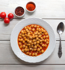 Vegetarian tasty spicy chick pea soup on a wooden background / Cheakpea stew/ Turkish nohut pilaki 