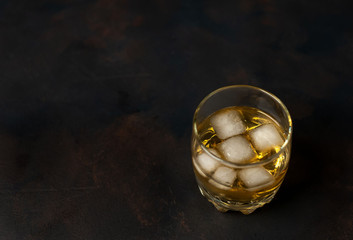 Whiskey with ice on concrete