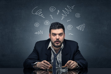 Young drunk man at his office with doodles around
