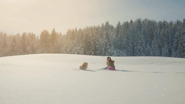 Teenage girl playing with an adorable dog in the snow