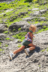 Naklejka na ściany i meble little girl climbing on a mountainside