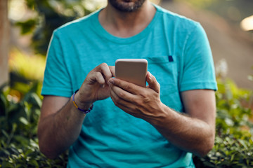 Modern man using cellphone outdoors.
