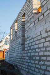 View of the back wall of the house under construction. Site on which the walls are built of gas concrete blocks